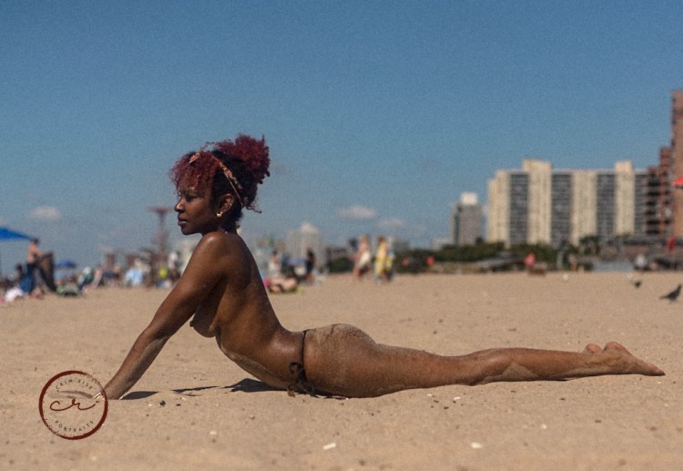 The woman is lying on the sand.